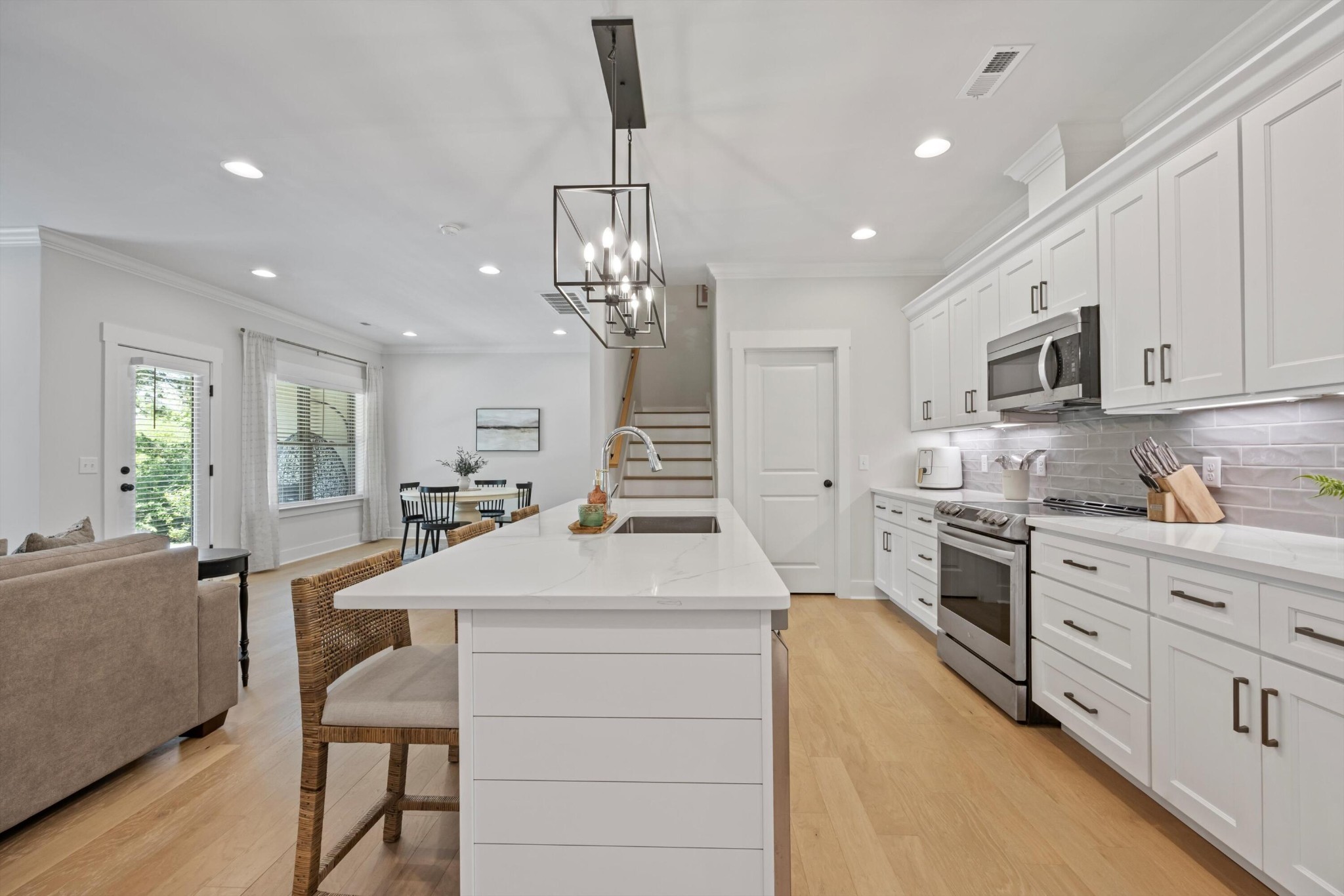 9638 Dutton Lane Ooltewah, TN 37363 - Photo 8 of 38 a large kitchen with kitchen island granite countertop lots of white cabinets appliances and furniture