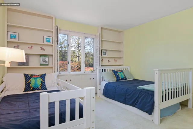 a bedroom with two beds and a large window