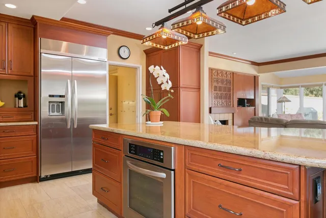 a kitchen with a refrigerator and countertop wooden floor