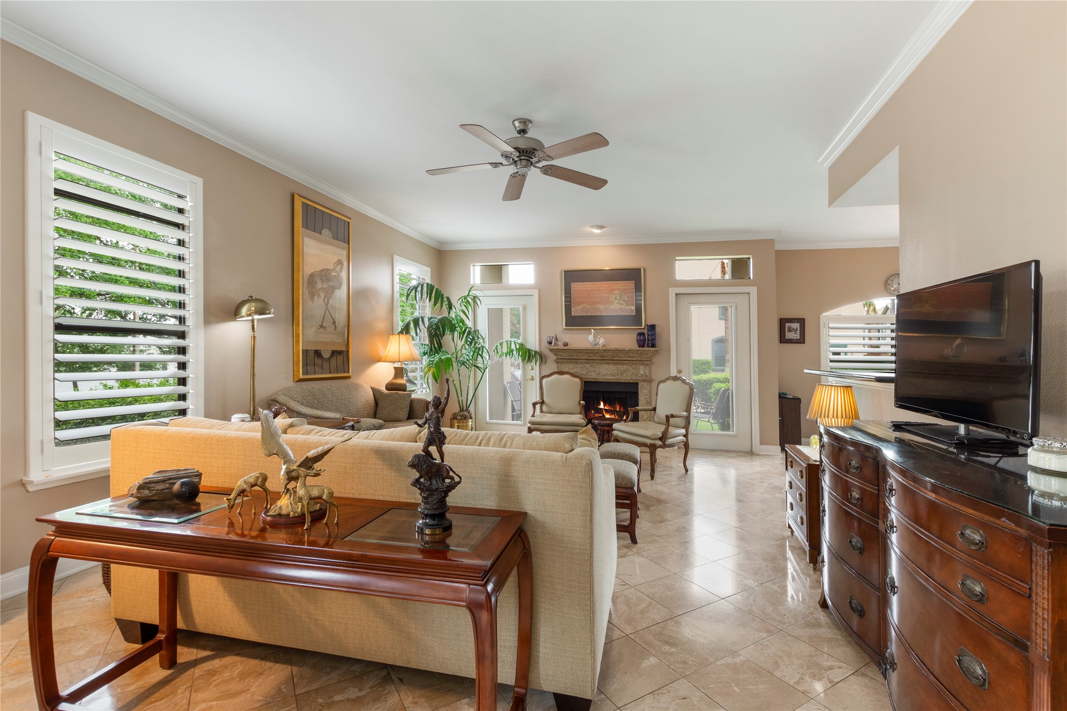 457 Mariners Drive Kemah, TX 77565 - Photo 7 of 25 Family room showing travertine floors, plantation shutters, fireplace.