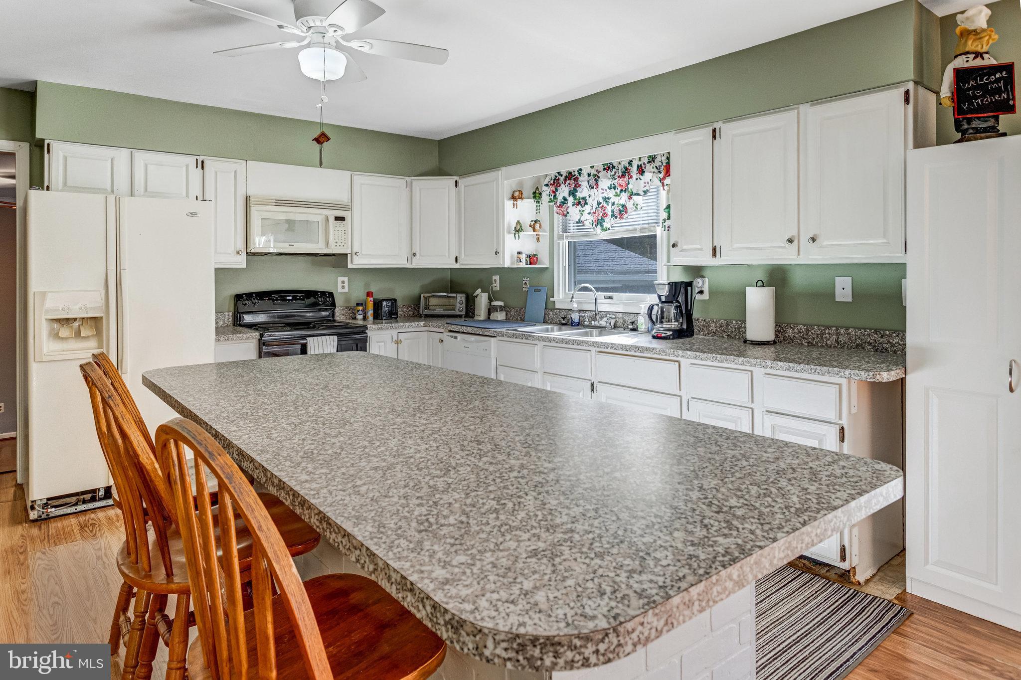 13200 Marsh Road Bealeton, VA 22712 - Photo 7 of 20 a kitchen with stainless steel appliances granite countertop a sink dishwasher and cabinets with wooden floor