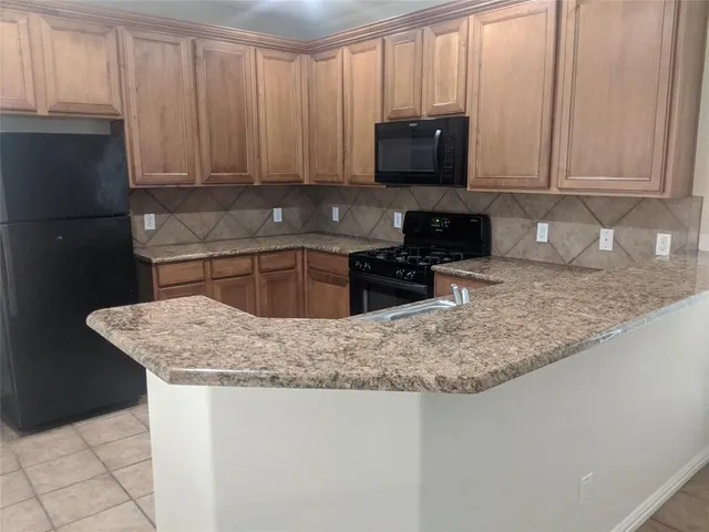 a kitchen with stainless steel appliances granite countertop a sink stove and microwave