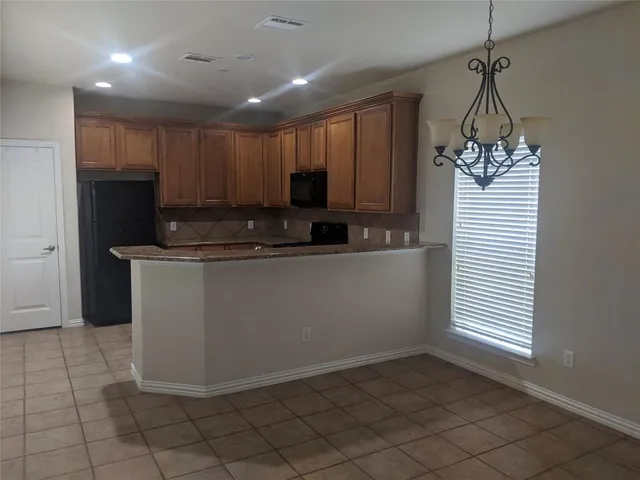 a kitchen with kitchen island stainless steel appliances a sink cabinets and a window