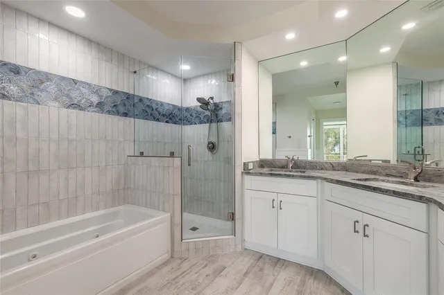 a bathroom with a granite countertop sink a large mirror and shower