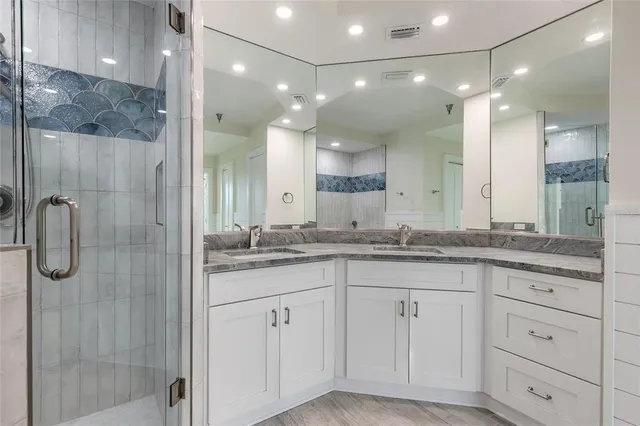 a bathroom with a granite countertop sink a shower and a mirror