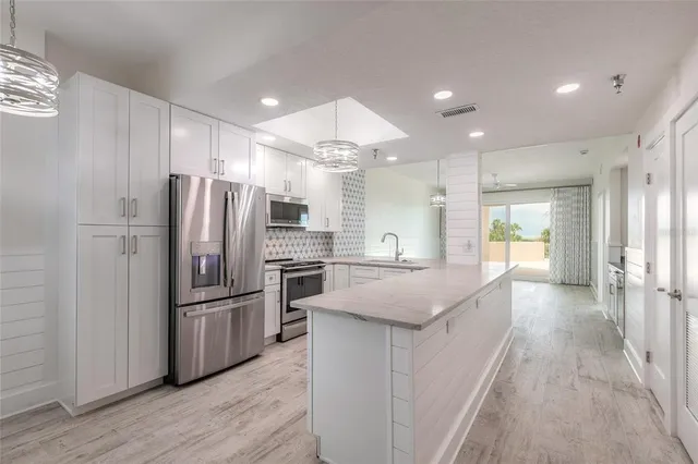 a kitchen with stainless steel appliances granite countertop a refrigerator and a sink