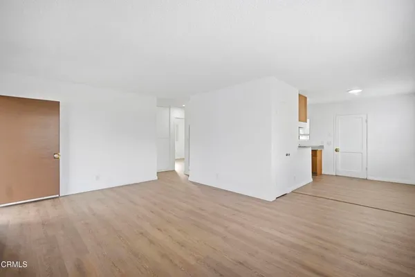 a view of empty room with wooden floor and window