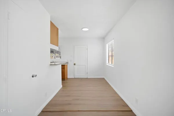 a view of a hallway with wooden floor and closet