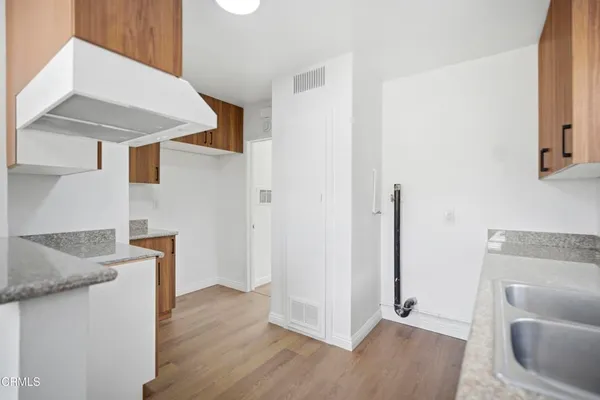 a hallway with wooden floor washer and dryer