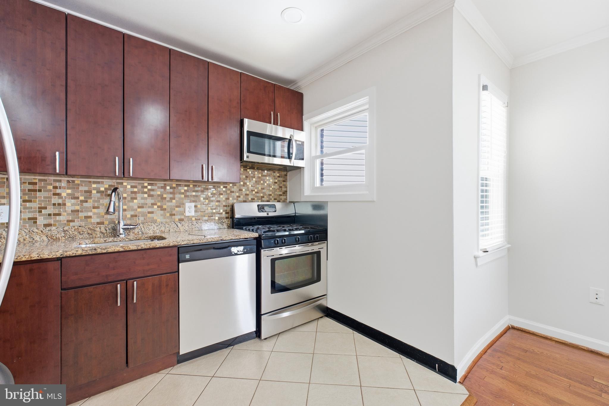 2712 6th Street Northeast Washington, DC 20017 - Photo 6 of 24 a kitchen with stainless steel appliances granite countertop a stove a sink and a microwave