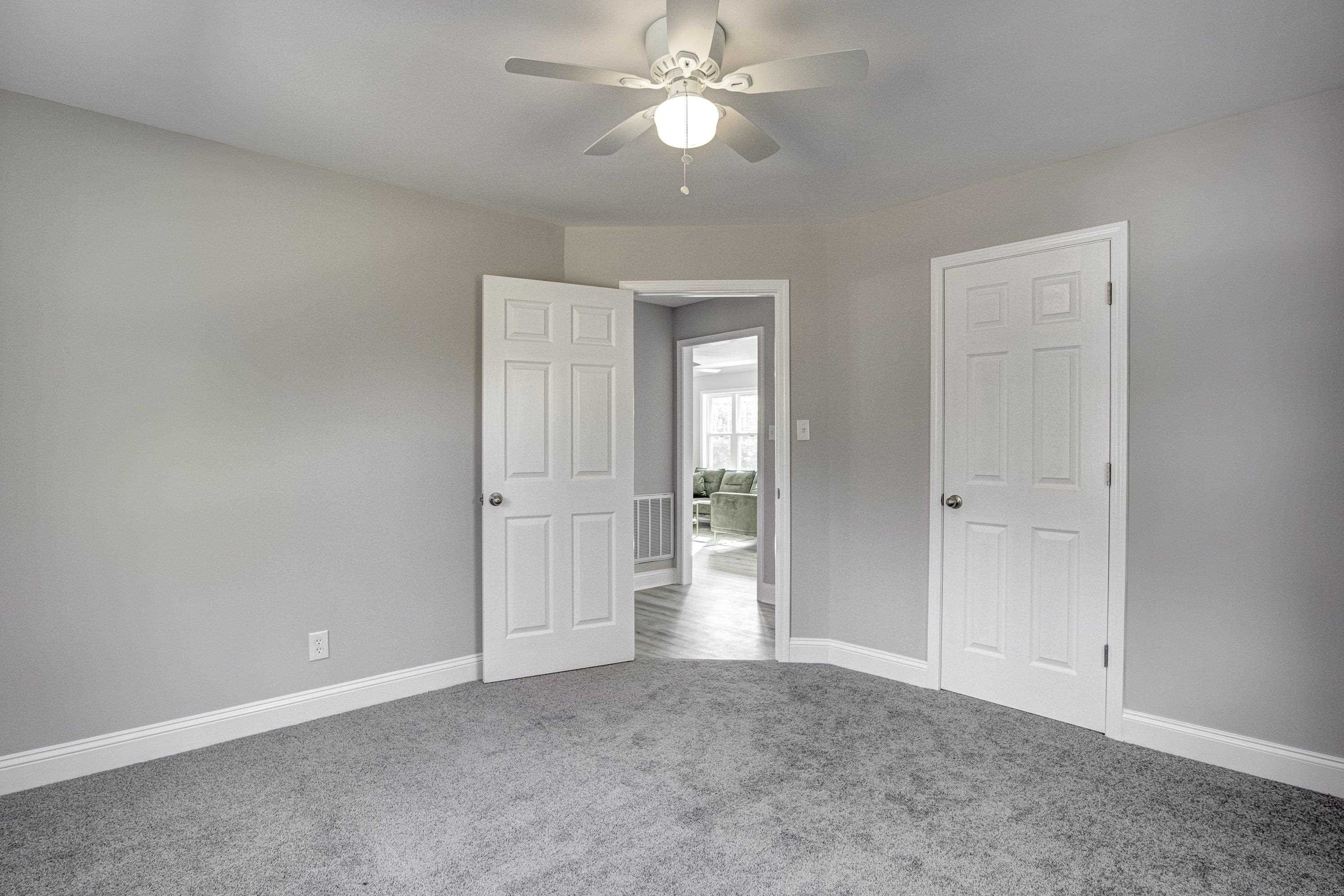 1111 Southerlund Road Garner, NC 27529 - Photo 23 of 29 an empty room with closet and a chandelier fan