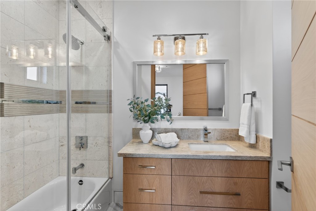 520 11th Street Huntington Beach, CA 92648 - Photo 25 of 65 a bathroom with a granite countertop sink a mirror and a shower