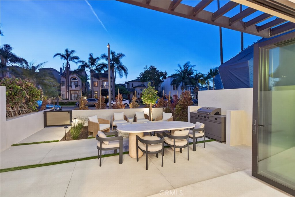 520 11th Street Huntington Beach, CA 92648 - Photo 63 of 65 a view of a patio with dining table and chairs under an umbrella