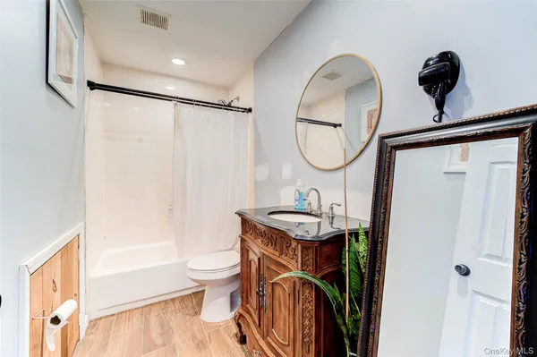 a bathroom with a sink a toilet and a mirror