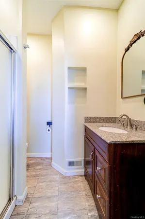 a bathroom with a granite countertop sink and a mirror