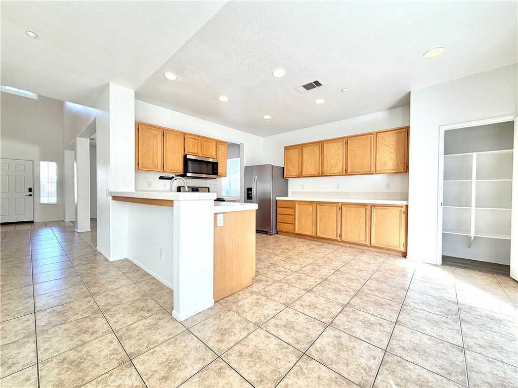 8182 Bon View Drive Riverside, CA 92508 - Photo 11 of 43 a view of kitchen with stainless steel appliances granite countertop a stove top oven a sink and a refrigerator