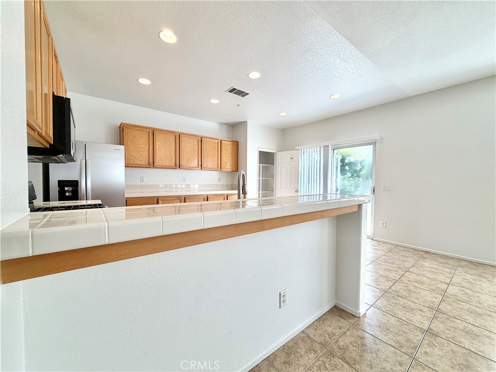 8182 Bon View Drive Riverside, CA 92508 - Photo 12 of 43 a large kitchen with stainless steel appliances a large counter top a stove and a refrigerator