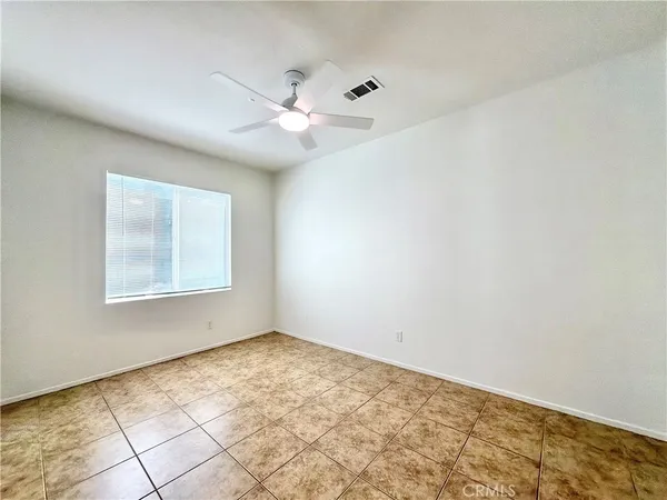 an empty room with a window and ceiling fan