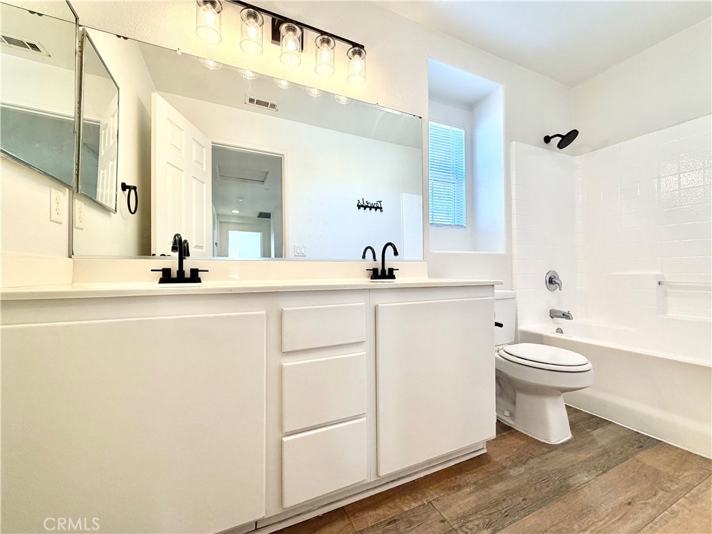 8182 Bon View Drive Riverside, CA 92508 - Photo 22 of 43 a bathroom with a sink a toilet and a mirror