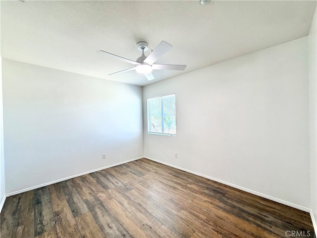 8182 Bon View Drive Riverside, CA 92508 - Photo 23 of 43 an empty room with wooden floor and fan