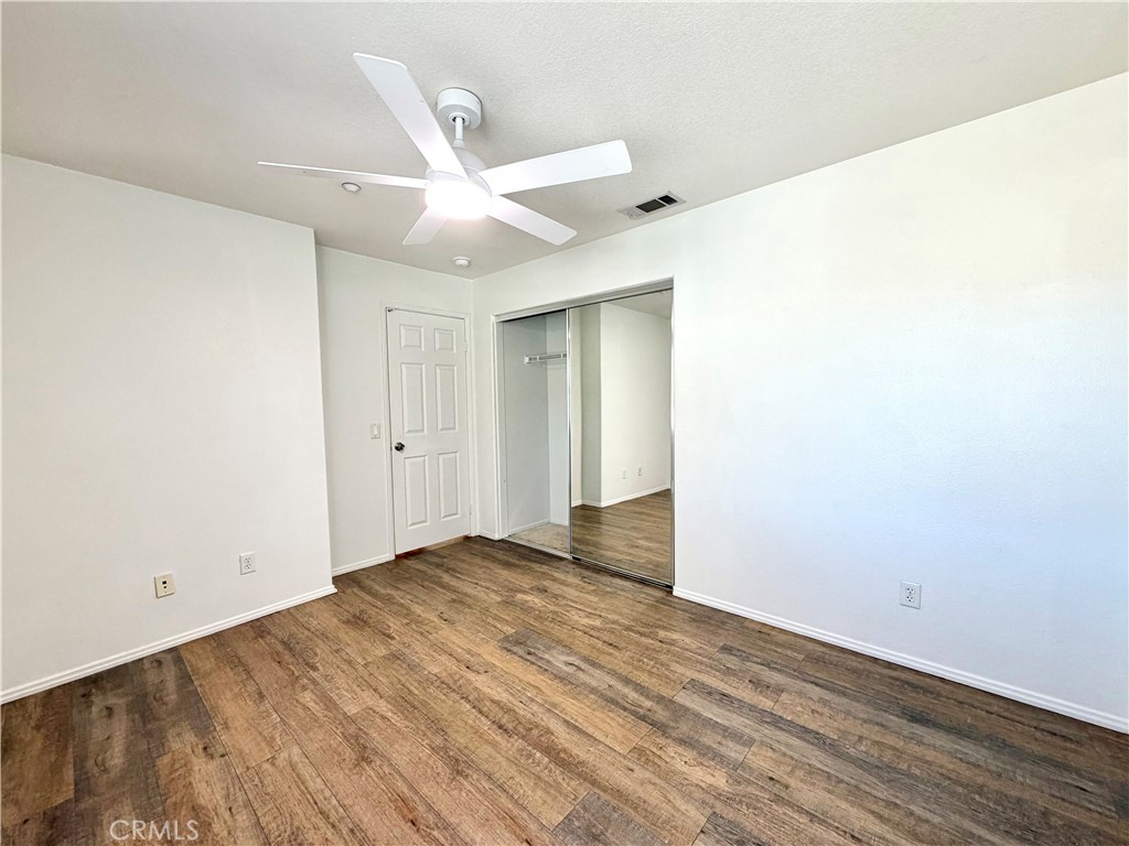 8182 Bon View Drive Riverside, CA 92508 - Photo 25 of 43 an empty room with wooden floor fan and windows