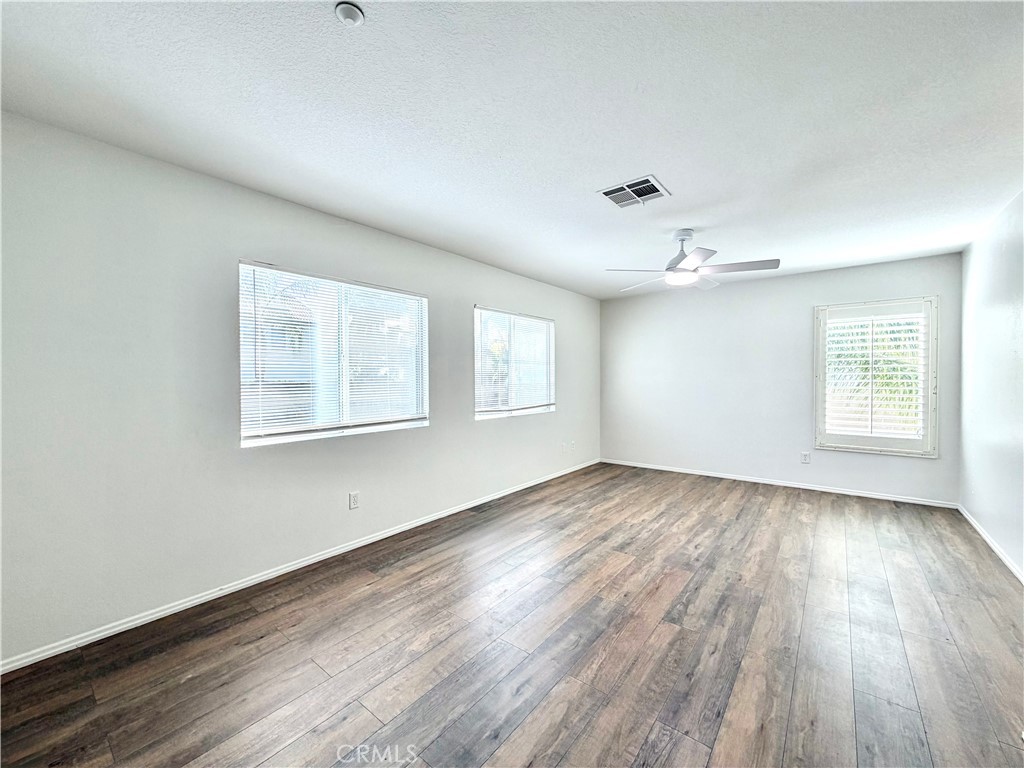 8182 Bon View Drive Riverside, CA 92508 - Photo 28 of 43 a view of an empty room with wooden floor and a window