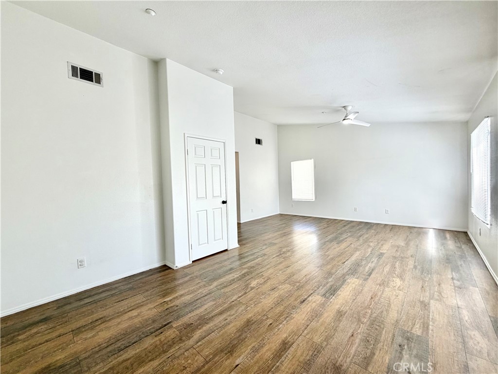 8182 Bon View Drive Riverside, CA 92508 - Photo 30 of 43 an empty room with wooden floor and windows