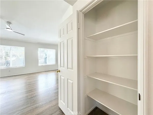 a view of an empty room with wooden floor and windows