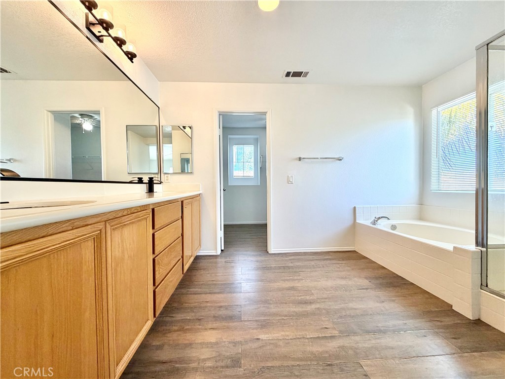 8182 Bon View Drive Riverside, CA 92508 - Photo 34 of 43 a bathroom with a sink a mirror and a bathtub