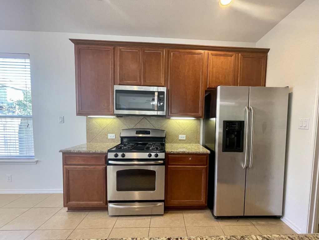 8725 White Ibis Drive Austin, TX 78729 - Photo 12 of 29 a kitchen with a refrigerator stove and microwave