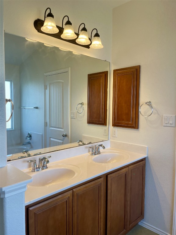 8725 White Ibis Drive Austin, TX 78729 - Photo 19 of 29 a bathroom with a double vanity sink and a mirror