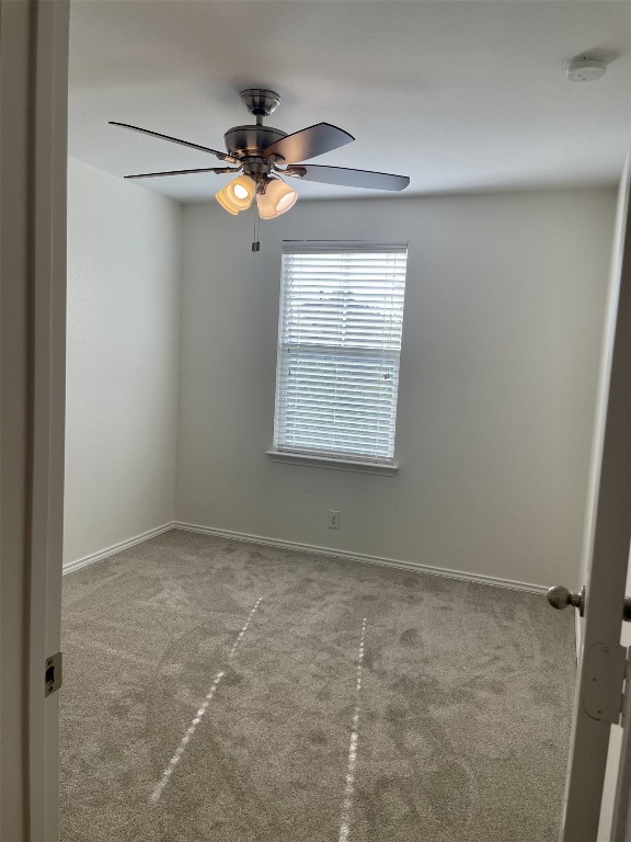 8725 White Ibis Drive Austin, TX 78729 - Photo 24 of 29 an empty room with a chandelier fan and windows