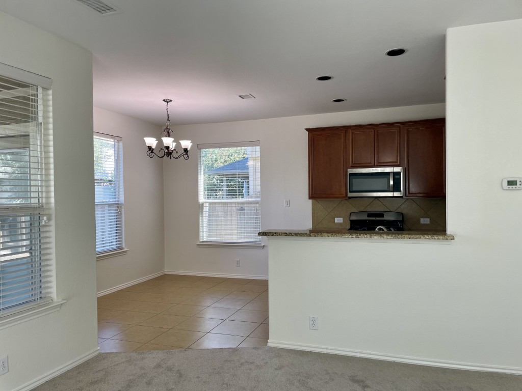 8725 White Ibis Drive Austin, TX 78729 - Photo 7 of 29 a view of a kitchen with a sink a dishwasher and cabinets