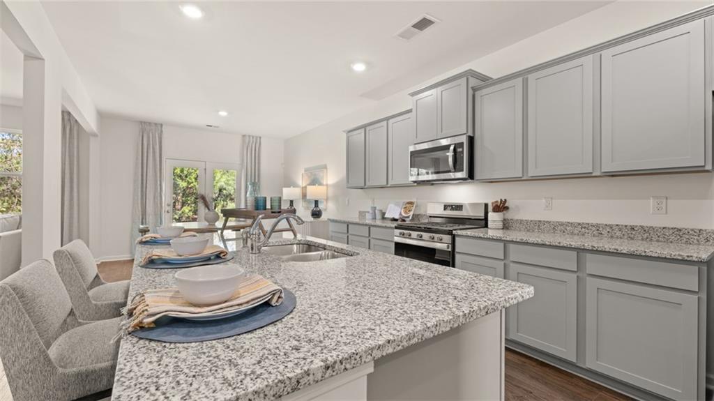 56 Weymouth Drive Locust Grove, GA 30248 - Photo 16 of 62 a kitchen with stainless steel appliances granite countertop a sink stove and cabinets