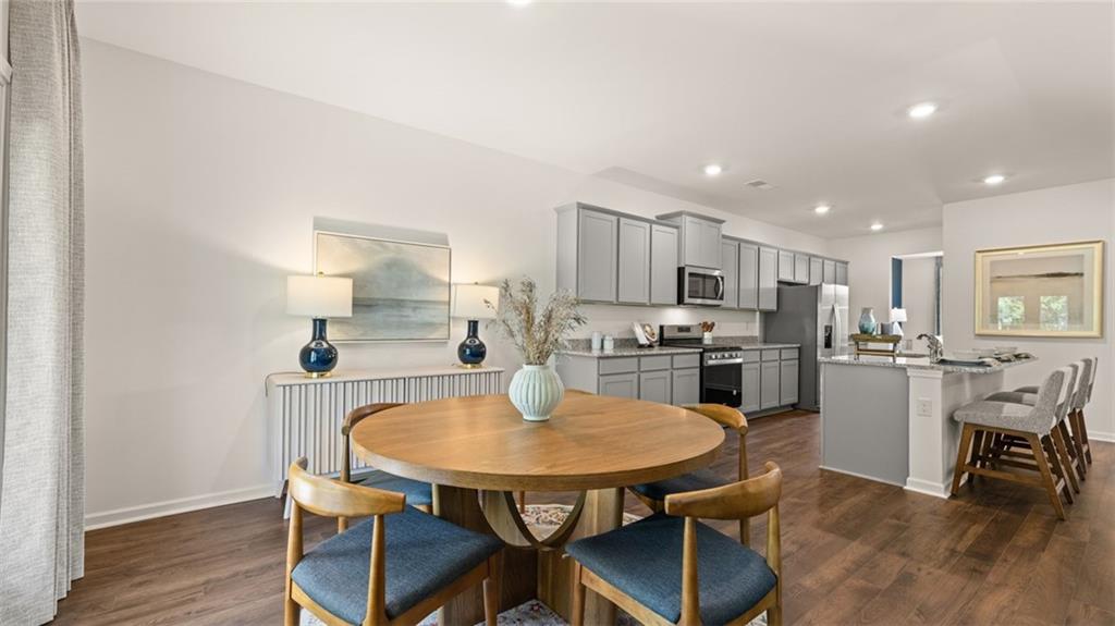 56 Weymouth Drive Locust Grove, GA 30248 - Photo 20 of 62 a kitchen with a dining table chairs and refrigerator