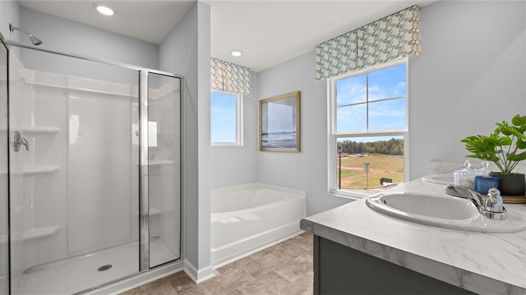 56 Weymouth Drive Locust Grove, GA 30248 - Photo 44 of 62 a bathroom with a granite countertop sink a mirror and a bathtub