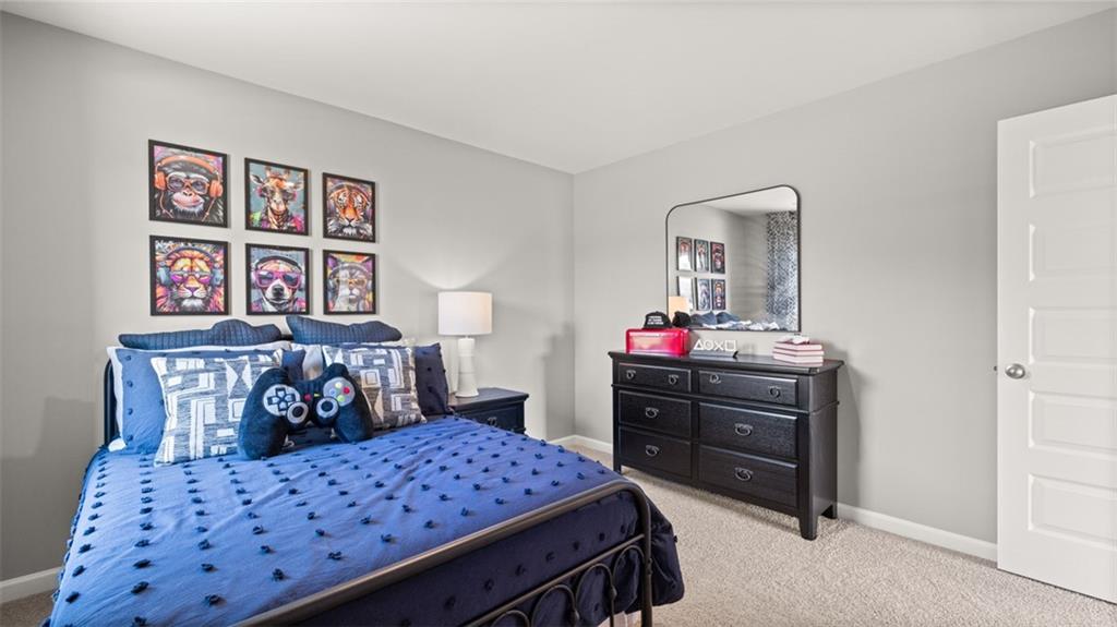 56 Weymouth Drive Locust Grove, GA 30248 - Photo 57 of 62 a bedroom with a bed a dresser and book shelf