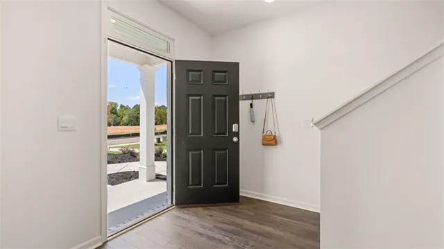 a kitchen with stainless steel appliances a stove a sink a refrigerator white cabinets and wooden floor