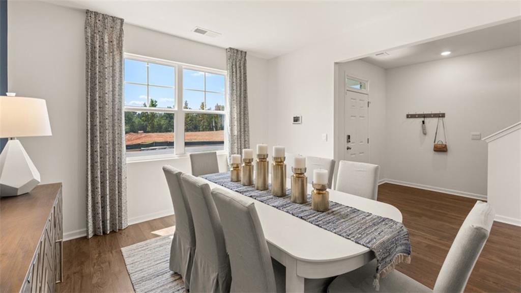 56 Weymouth Drive Locust Grove, GA 30248 - Photo 9 of 62 a dining room with furniture a rug and wooden floor