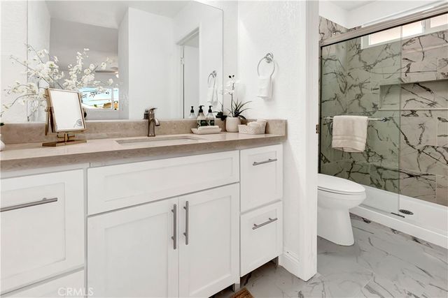 a bathroom with a double vanity sink mirror and toilet