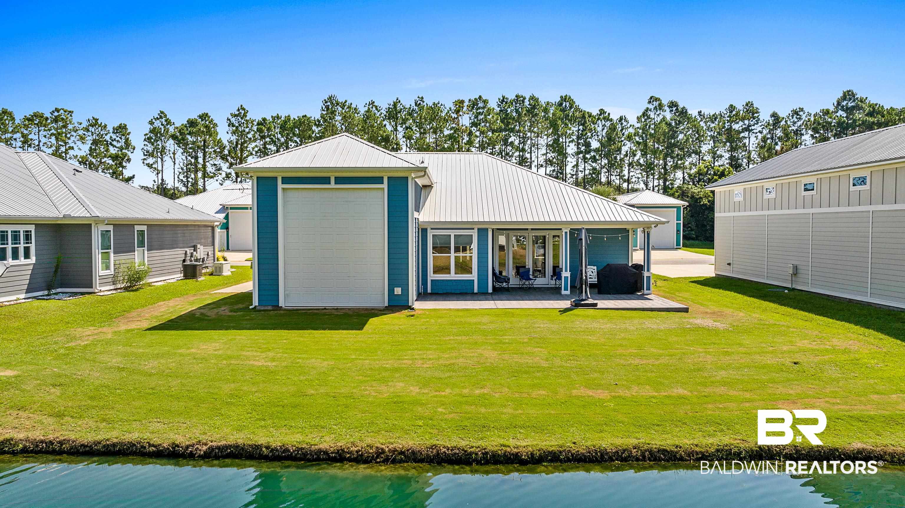 12329 Reunion Place, Unit LOT 38 Foley, AL 36535 - Photo 38 of 43 Rear view of house featuring a water view, a yard, and a metal roof