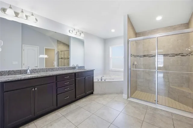 a bathroom with a granite countertop sink mirror and bathtub
