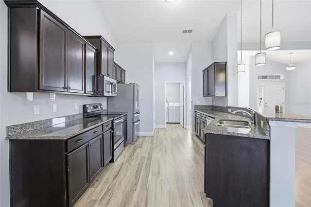 a kitchen with stainless steel appliances granite countertop a sink stove and refrigerator