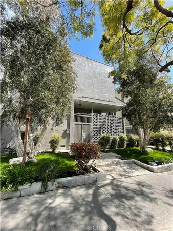 a front view of a house with a yard and potted plants