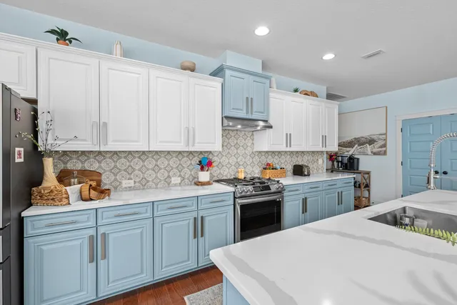a kitchen with white cabinets sink and stainless steel appliances