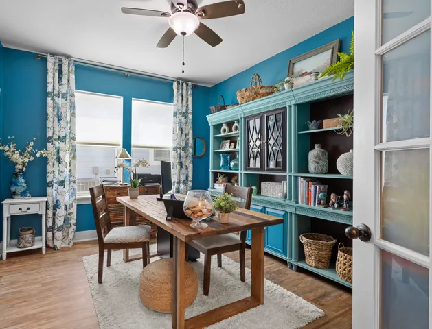 a living room with furniture a bookshelf and a window