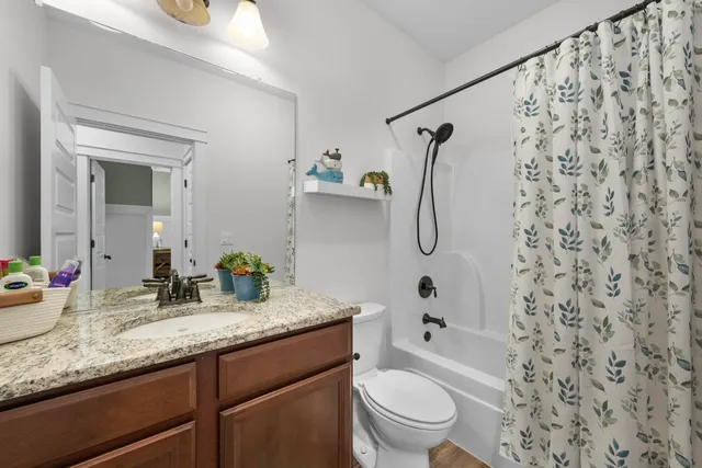 a bathroom with a granite countertop sink toilet and shower