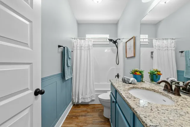 a bathroom with a granite countertop tub sink and mirror