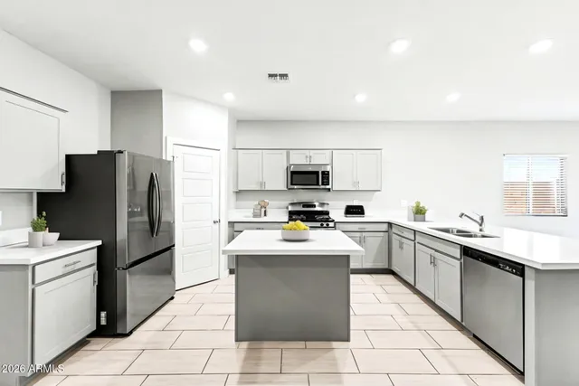 a kitchen with stainless steel appliances granite countertop a refrigerator sink stove and oven