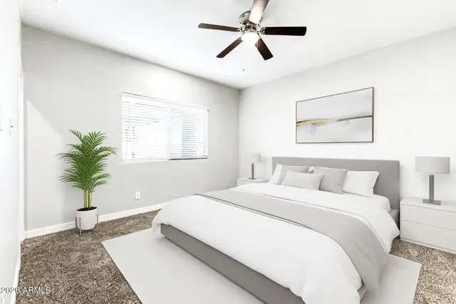 a bedroom with a large bed and a potted plant